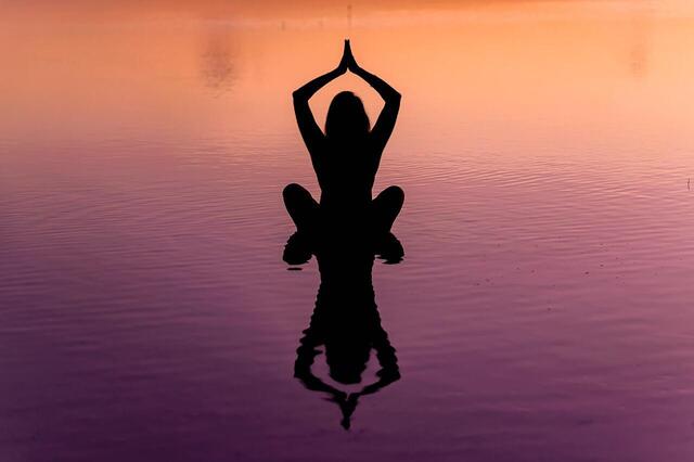 Person doing yoga in sunset